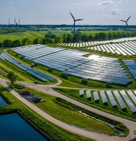 Environmentally friendly installation of photovoltaic power plant and wind turbine farm situated by landfill.Solar panels farm built on a waste dump and wind turbine farm. Renewable energy source.